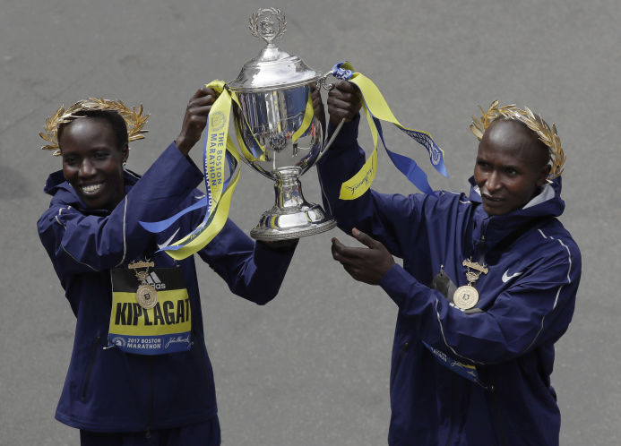 Edna Kiplagat left and Geoffrey Kirui both of Kenya hold a trophy together after their victories in the 121st Boston Marathon on Monday