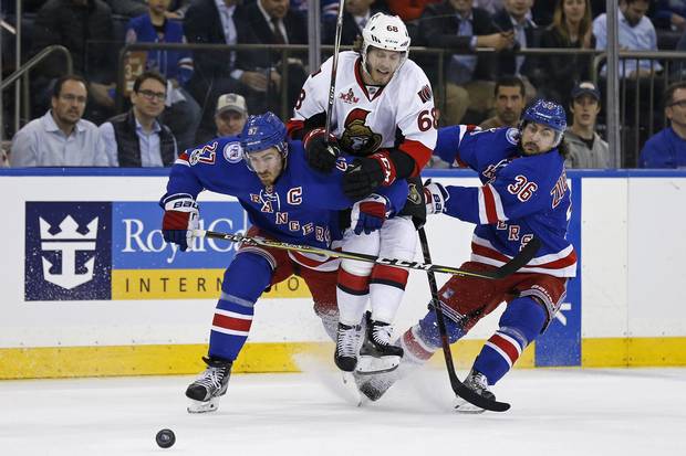 Senators left winger Mike Hoffman centre loses track of the puck as he’s squeezed between Ryan McDonagh left and Mats Zuccarello of the Rangers on Thursday