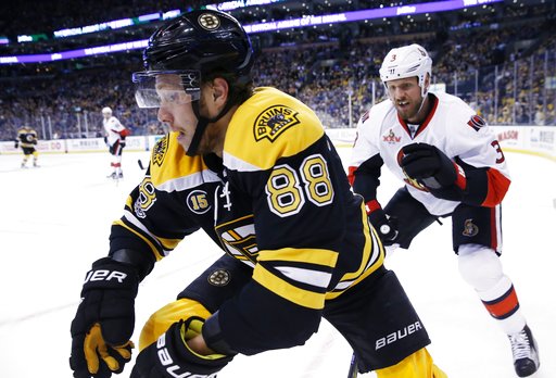 Boston Bruins David Pastrnak, of the Czech Republic and Ottawa Senators Marc Methot battle along the boards during the second period in Game 6 of a first-round NHL hockey Stanley Cup playoff series Sunday April 2