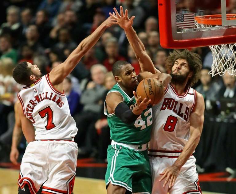 Al Horford of the Boston Celtics puts up a shot between Michael Carter Williams and Robin Lopez of the Chicago Bulls during Game Three of the Eastern Conference Quarterfinals