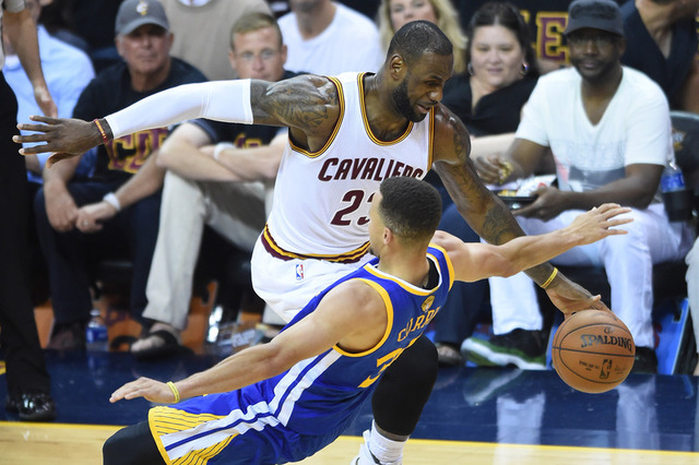 Cleveland Cavaliers forward Le Bron James dribbles the ball past Golden State Warriors guard Stephen Curry during last year's NBA Finals