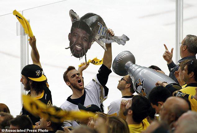 A Pittsburgh Penguins fan holds a catfish sign adorned with the face of Nashville Predators P.K. Subban during the second period in Game 5 of the NHL hockey Stanley Cup Final Thursday