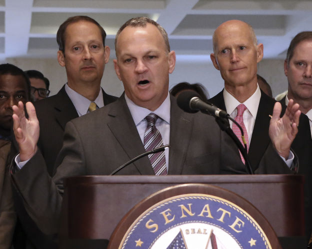 Florida House Speaker Richard Corcoran R Land O'Lakes addresses legislators and media at the end of the special session on Friday as Senate President Joe Negron R-Stuart left and Gov. Rick Scott look