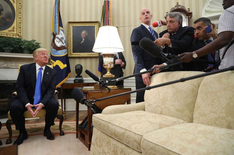 President Donald Trump answers a question from the media during a meeting with Romanian President Klaus Werner Iohannis not shown in the Oval Office at the White House Friday