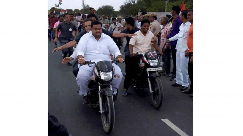 Congress vice-president Rahul Gandhi rides pillion on a bike on his way to Madhya Pradesh's Mandsaur the epicenter of violent farmer protests that have escalated over the death of five in police firing