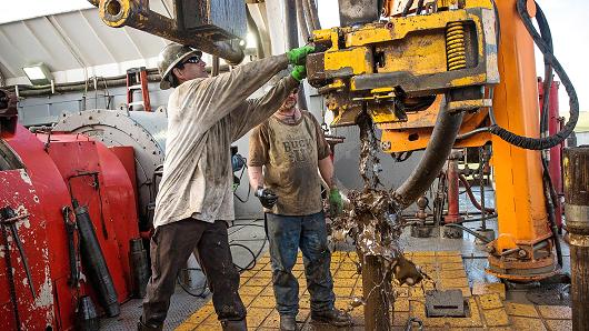 Workers line up pipe while drilling for oil in the Bakken shale formation outside Watford City N.D