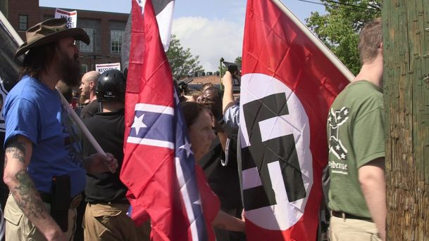 Demonstrators carry confederate and Nazi flags during the Unite the Right free speech rally at Emancipation Park in Charlottesville Virginia USA