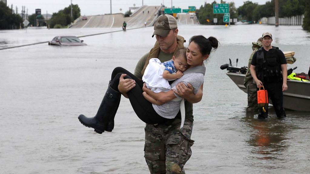 Houston Police SWAT officer Daryl Hudeck carries Catherine Pham and her son Aiden after rescuing them from their home surrounded by floodwaters from Tropical Storm Harvey