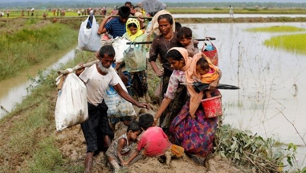 A group of Rohingya refugees walk on the muddy path after crossing the Bangladesh Myanmar border in Teknaf Bnagladesh