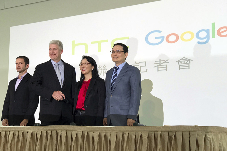 Rick Osterloh senior vice president of hardware for Google second from left and Cher Wang chairperson of HTC shake hands during a press conference in New Taipei City Taiwan Thursday Sept. 21 2017. Google is biting off a big piece of device manufa