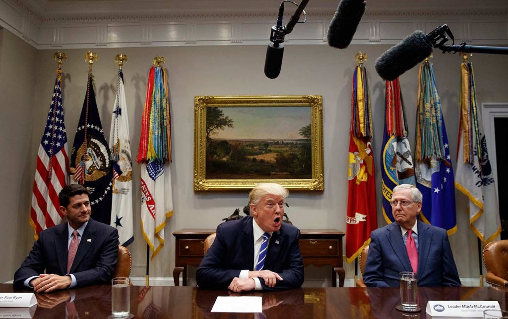 House Speaker Paul Ryan left and Senate Majority Leader Mitch McConnell right listen as Donald Trump speaks during a meeting on tax reform in the White House