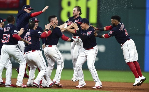 Cleveland Indians Yan Gomes center is mobbed by teammates after the Indians defeated the New York Yankees 9-8 in 13 innings in Game 2 of a baseball American League Division Series Friday Oct. 6 2017 in Cleveland