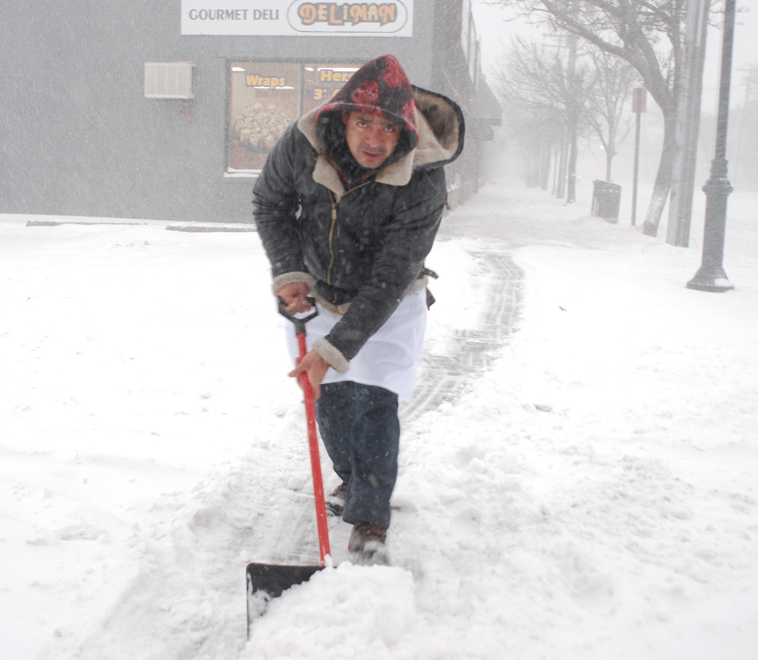 A worker who did not wish to be identified cleaned up a sidewalk in downtown Merrick around 8 a.m. Thursday