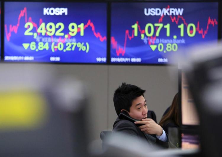 A currency trader talks on the phone at the foreign exchange dealing room of the KEB Hana Bank headquarters in Seoul South Korea Thursday Jan. 11 2018. Asian stock markets were lower on Thursday after Wall Street posted its first loss this year. Repor