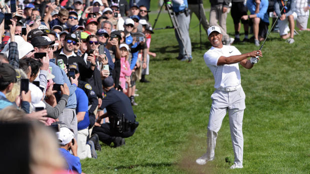 The Latest: Woods drops back to even with 1 hole to play