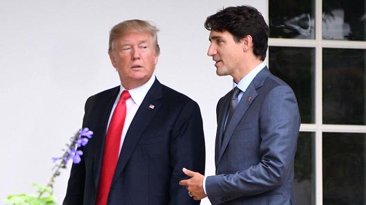 President Donald Trump listens to Canadian Prime Minister Justin Trudeau as they walk towards the Oval Office of the White House in Washington DC