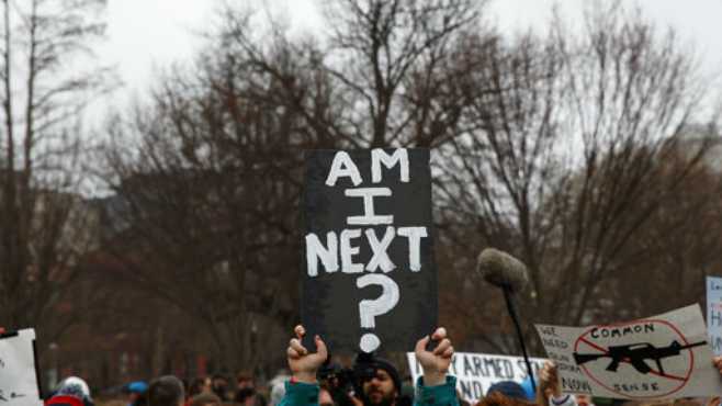 Demonstrators hold signs during a protest in favor of gun control reform in front of the White House Monday Feb. 19 2018 in Washington