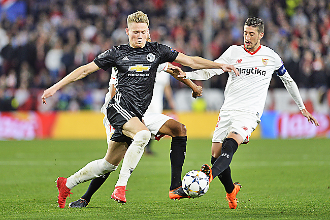 Manchester United’s 21-year-old midfielder Scott Mc Tominay fights for the ball with Sevilla’s defender Sergio Escudero