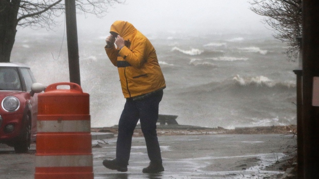 A man walks near the coastline Friday in Newburyport Mass. as a powerful nor'easter pounds the U.S. East Coast packing heavy rain intermittent snow and strong winds