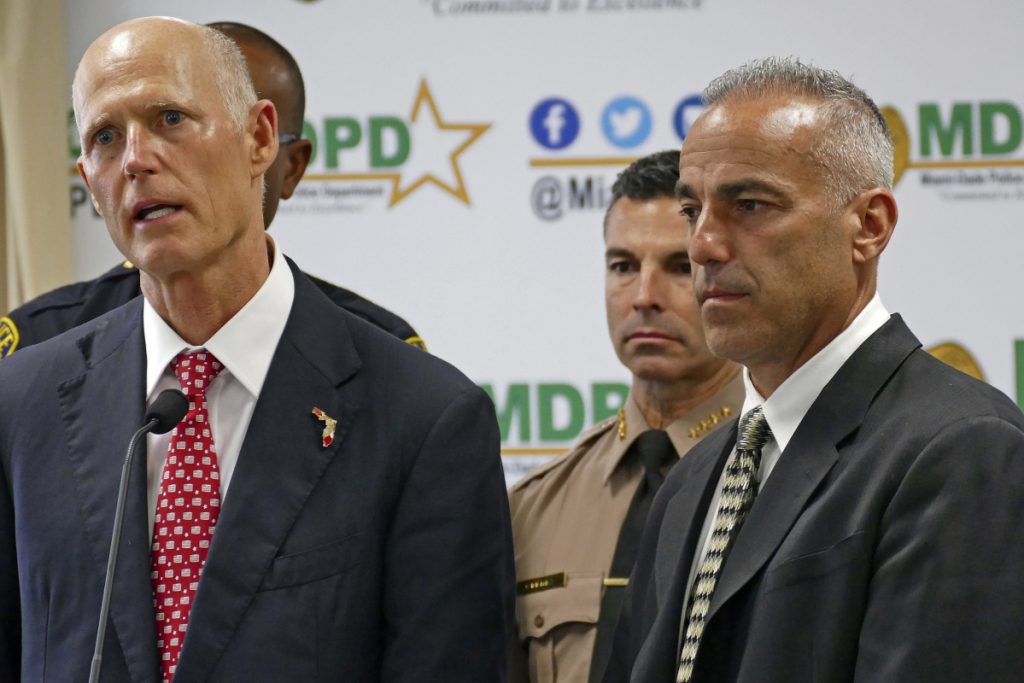 Florida Gov. Rick Scott talks alongside Andrew Pollack right whose daughter Meadow was murdered in Parkland during a news conference in Doral Fla. on Feb. 27