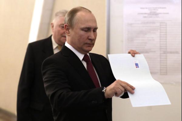 Russian President holds his ballot at a polling station during the presidential election in Moscow on Sunday