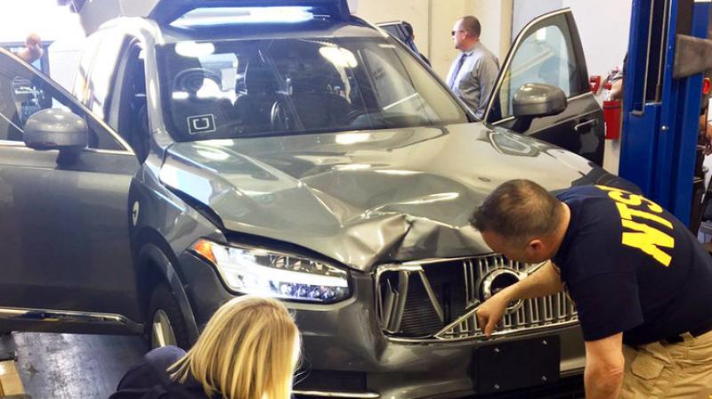 National Transportation Safety Board investigators examine a driverless Uber SUV that fatally struck a woman in Tempe Ariz