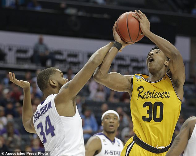 UMBC's Daniel Akin is fouled by Kansas State's Levi Stockard III during the first half of a second-round game in the NCAA men's college basketball tournament in Charlotte N.C. Sunday