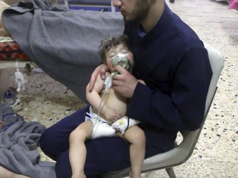 A medical worker gives toddlers oxygen following an alleged poison gas attack in Douma