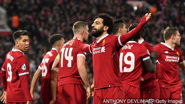 TOPSHOT- Liverpool's Egyptian midfielder Mohamed Salah celebrates with teammates scoring the team's first goal during the UEFA Champions League first leg quarter-final football match