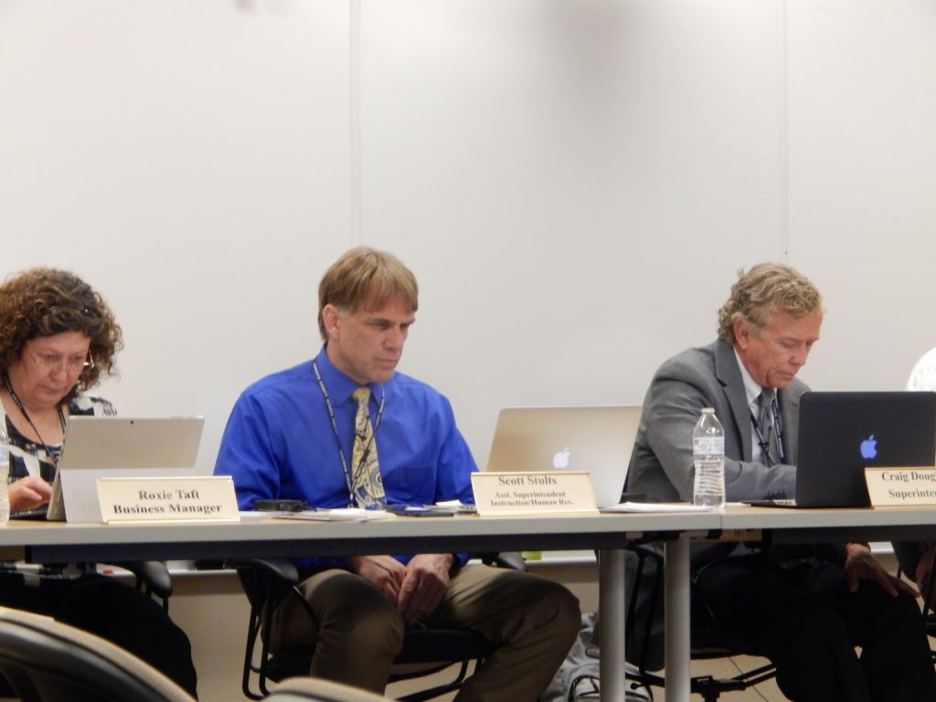 Assistant Superintendent Scott Stults center at the school board meeting earlier this week. At left is Business Manager Roxie Taft and at right Superintendent Craig Dougherty