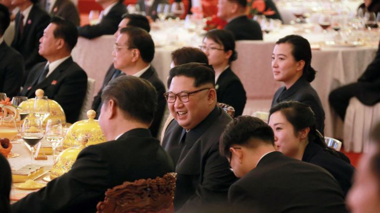 North Korean leader Kim Jong Un center smiles