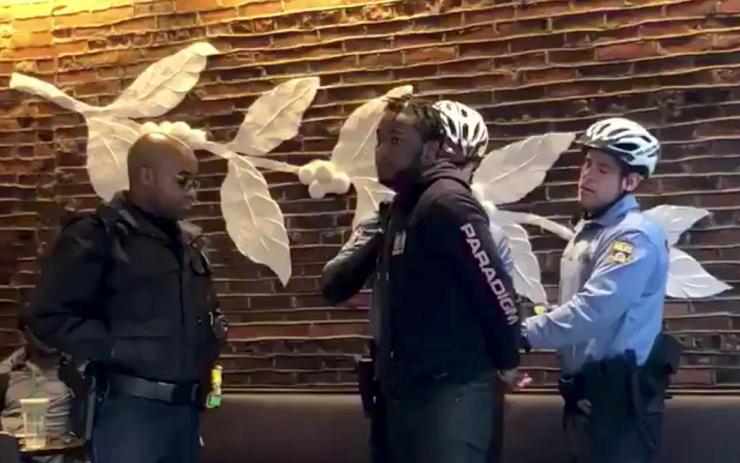 Police officers detain a man inside a Starbucks cafe in Philadelphia Pennsylvania U.S