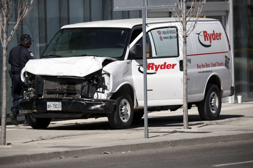 Police inspect a van involved in a collision killing 10 people at Yonge Street and Finch Avenue in Toronto Canada that may have been carried out by an incel