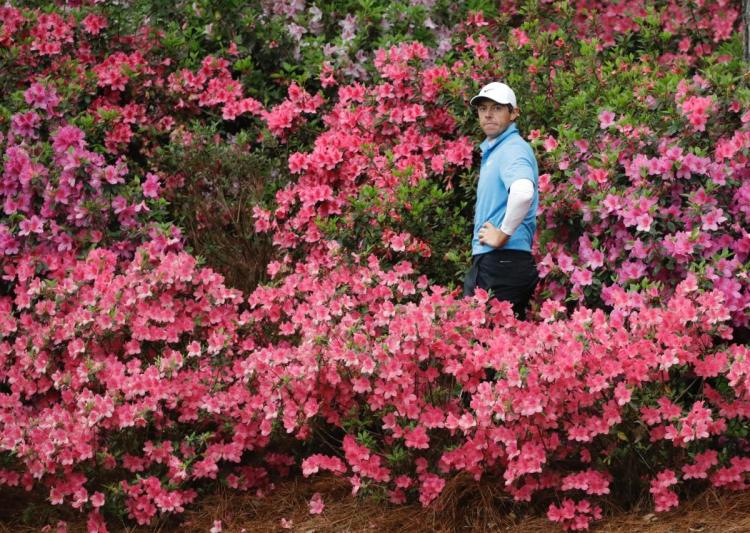 Rory McIlroy of Northern Ireland hits from the azaleas on the 13th hole during the third round at the Masters golf tournament Saturday