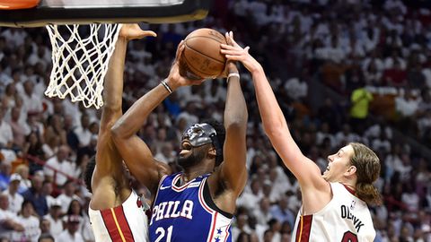 MIAMI FL- APRIL 19 Joel Embiid #21 of the Philadelphia 76ers drives to the basket while being defended by Kelly Olynyk #9 and Hassan Whiteside #21 of the Miami Heat during the second quarter of the game at American Airlines Arena