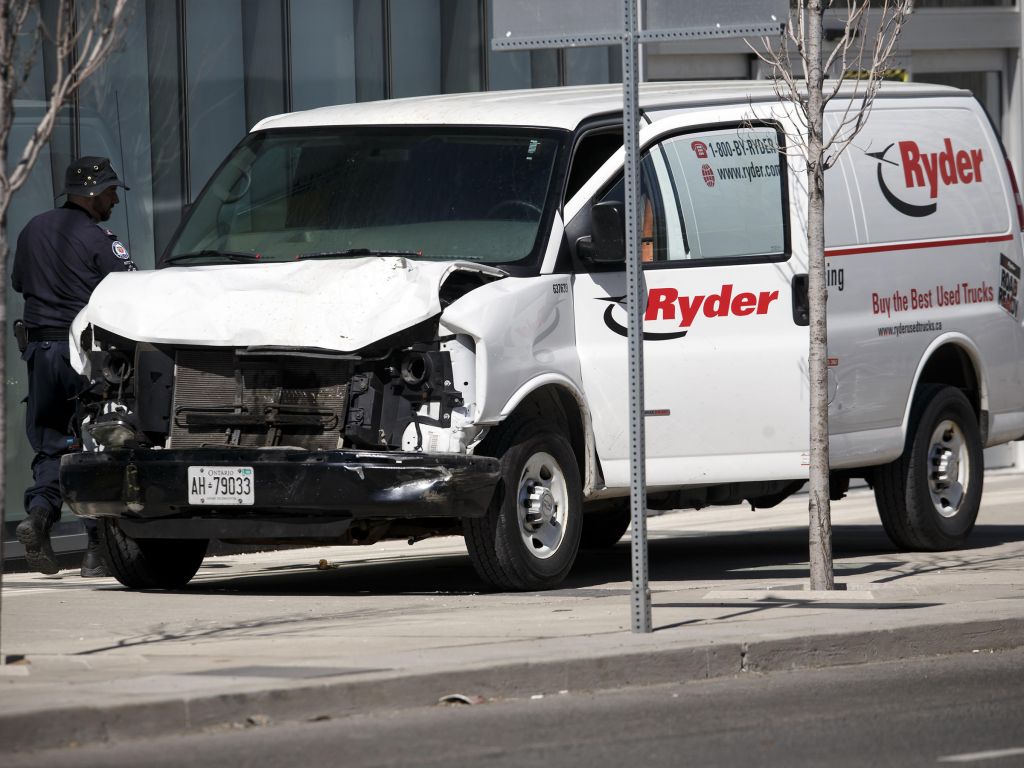 Police inspect a van suspected of being involved in a collision that killed at least nine people and injured 16 others in Toronto on Monday