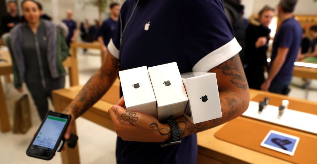 An Apple Store staff shows Apple's new iPhones X after they go on sale at the Apple Store in Regents Street London Britain