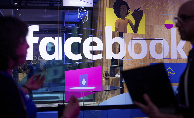 Conference workers speak in front of a demo booth at Facebook’s annual F8 developer conference in San Jose Calif. in April 2017