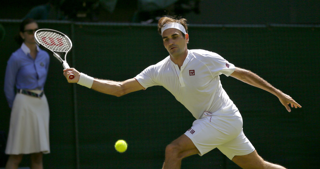 Roger Federer of Switzerland returns to Serbia's Dusan Lajovic during their Men's Singles first round match at the Wimbledon Tennis Championships in London