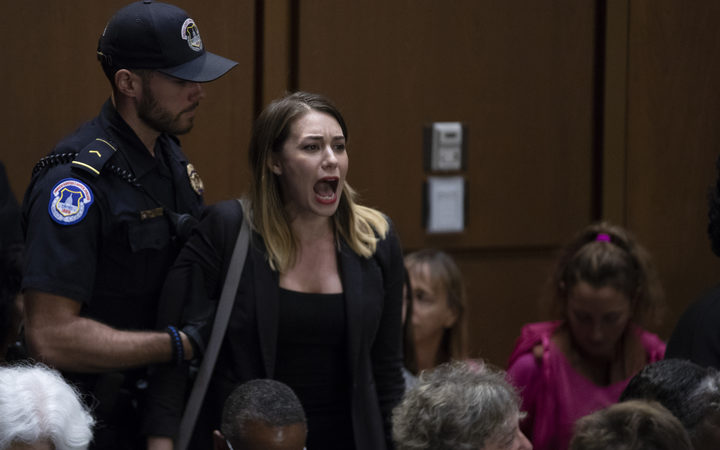 A demonstrator shouts as Judge Brett Kavanaugh arrives prior to a hearing before the United States Senate Judiciary Committee on his nomination as Associate Justice of the US Supreme Court