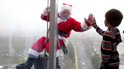 Santa cleaning windows to cheer the sick kids