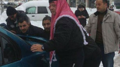 See king of Jordan pushing car to help a group of men