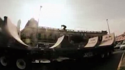 A BMX rider performed awesome backflip stunt in-between two trucks