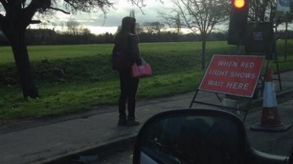 Woman walking on foot stops at the traffic red signal