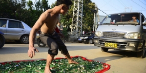 Man barefoot on broken glass pulling a 3-ton truck just using his teeth in attempt to create a world record