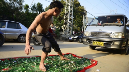 Man barefoot on broken glass pulling a 3-ton truck just using his teeth in attempt to create a world record