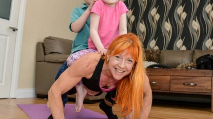 Mother keeps herself fit using her two kids weights