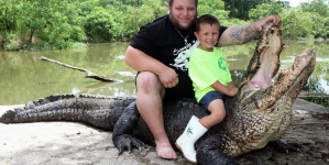 Father is teaching his young son to control the alligator in attempt of continuing their family tradition