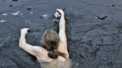 Swimmer saved the duck which got stuck into the frozen lake