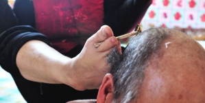 Disabled woman shaves her husband’s head using her feet